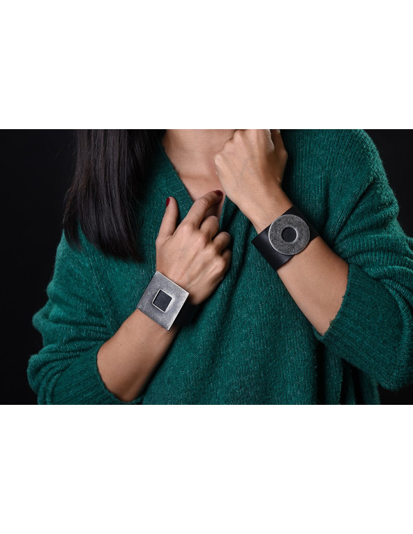 Wide black leather bracelet with matte steel circle and bold minimalist design