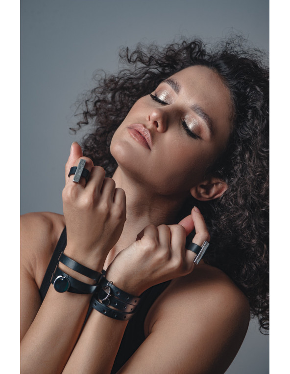 Black leather bracelet with decorative charms and gold clasp