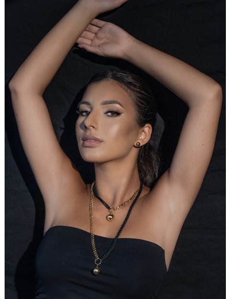 Long adjustable gold-plated stainless steel necklace with ball pendant in gold and matte black tones.