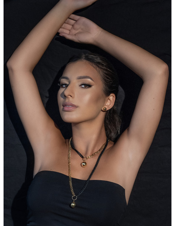 Short adjustable gold-plated stainless steel necklace with a sphere in gold and matte black tones.