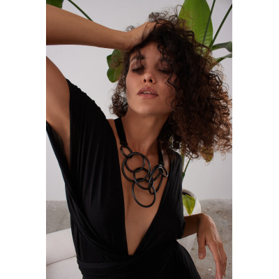 Adjustable necklace with matte black stainless steel circles on a black velvet ribbon tied into a bow. 2