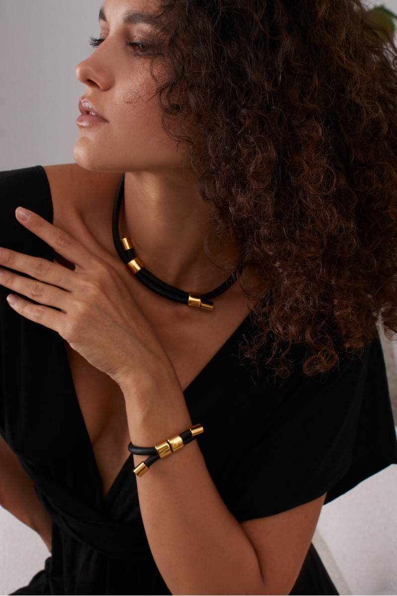 Black leather and gold-plated steel jewelry set with modern design