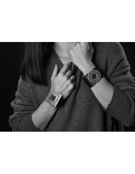 Black leather bracelet with a large, glossy gold-plated stainless steel element