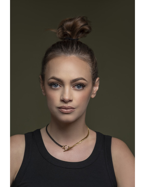 Delicate stainless steel necklace in gold and matte black with a decorative clasp.