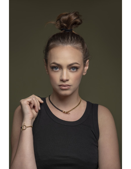 Delicate stainless steel necklace in gold and matte black with a decorative clasp.