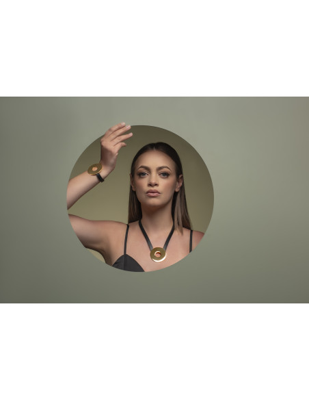 Black leather necklace with large shiny gold-plated stainless steel circular pendant.