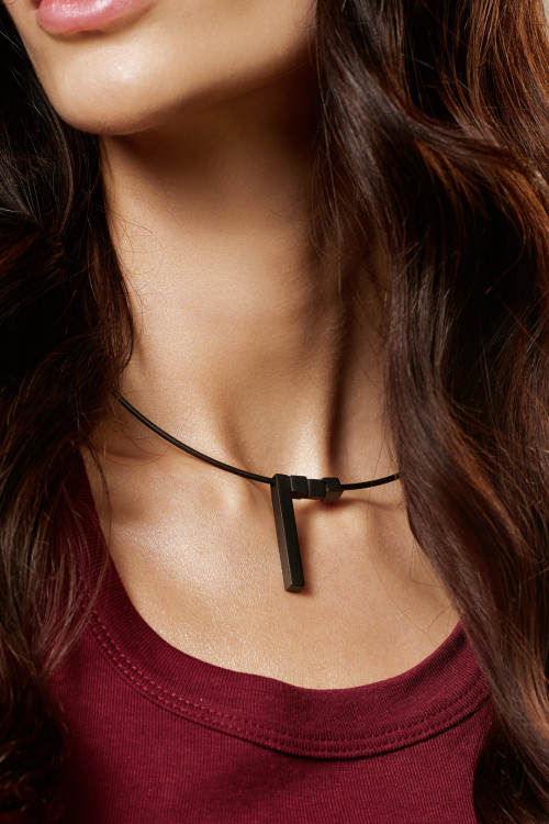 A delicate matte black stainless steel necklace with charms