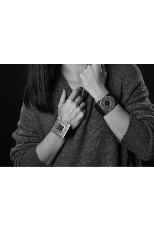 Black leather bracelet with a large, glossy gold-plated stainless steel element