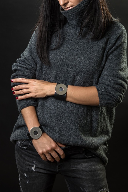 Wide black leather bracelet with matte steel circle and bold minimalist design
